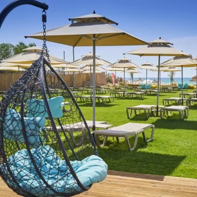 Jardin avec fauteuil suspendu et parasols au Mondi Club Nozha Beach Hammamet