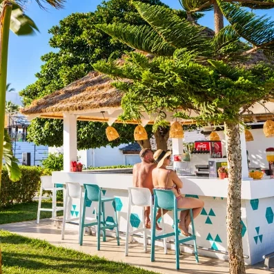 Bar de plage paillote avec tabourets turquoise au Mondi Club Nozha Beach Resort & Spa Hammamet.