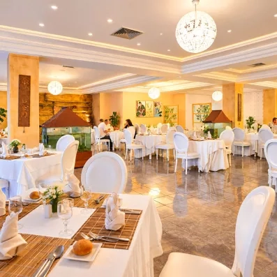 Salle de restaurant de luxe aux chaises blanches au Mondi Club One Resort Jockey