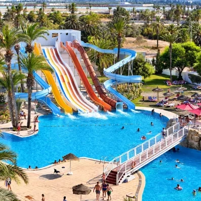 Grand parc aquatique extérieur du Mondi Club One Resort Jockey à Monastir en Tunisie avec toboggans multicolores et grands bassins.