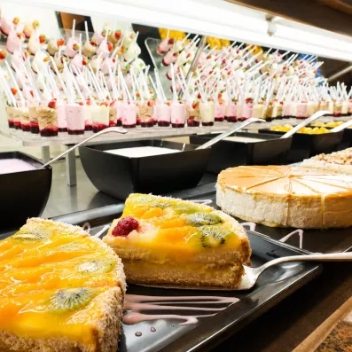 Une rangée de verrines de dessert est disposée sur une étagère en verre.