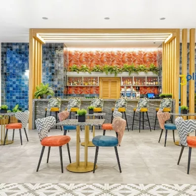 Une salle de restaurant lumineuse, avec des chaises et des tables parfaitement dressées.