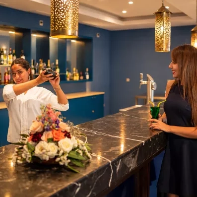 bar bleu avec serveuse préparant un cocktail 