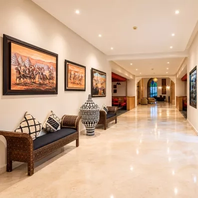hall de l'hôtel, avec une boutique à souvenirs à droite, le café maure au fond et des tableaux décoratifs 