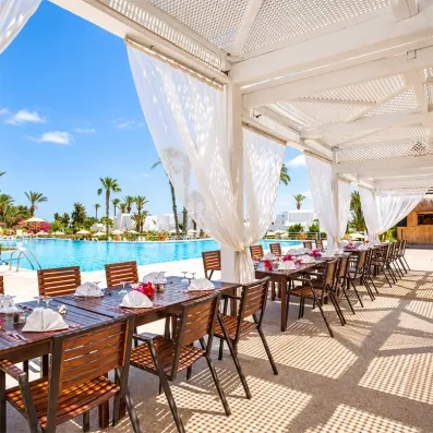 Terrasse du restaurant du club tout inclus Seabel Aladin Djerba surplombant la piscine.