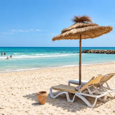 Parasol en paille et transats sur la plage privée du Mondi Club Seabel Aladin Djerba