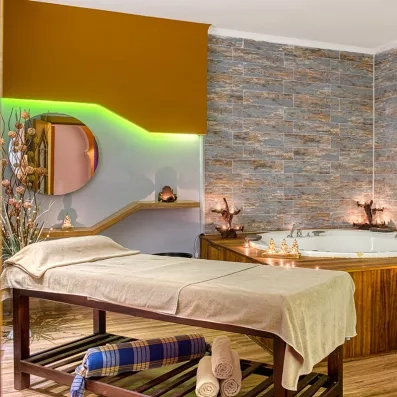 espace de détente avec une table de massage et un jacuzzi