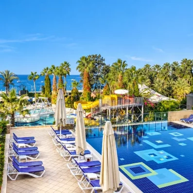 piscine extérieur avec transats et parasols et en fond la mer