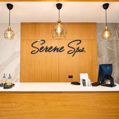 comptoir centre de spa réception, ordinateur et clavier et souris, trois luminaires 
