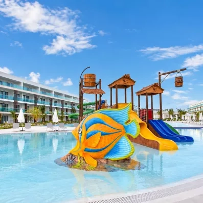 toboggans aquatiques, décoration marine poisson jaune et bleu, pour les enfants, hôtel en arrière-plan parasols et transats, ciel bleu et nuages