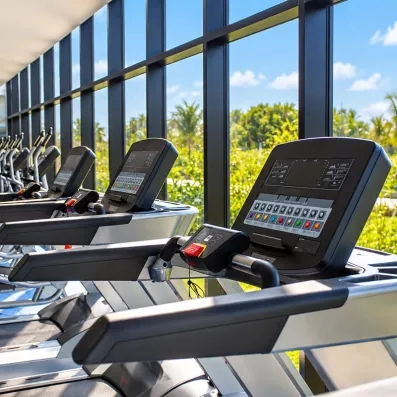 salle de fitness, machines de sport, tapis de course, vue sur l'extérieur, végétation luxuriante