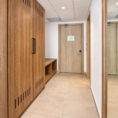 couloir de chambre, grande armoire en bois, emplacement pour mettre les chaussures, et grand miroir