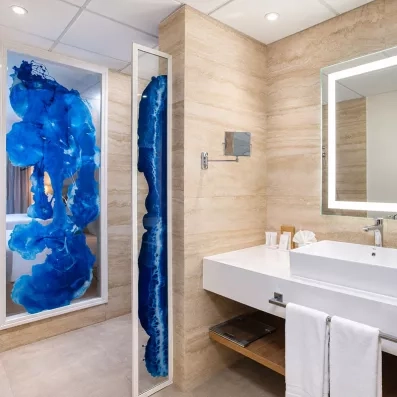 salle de bains avec douche et sèche-cheveux, grand miroir avec de la lumière, vasque carrée, petit miroir grossissant