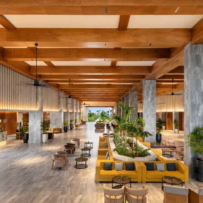lobby, canapés jaunes, plafond colonial en bois, plantes au centre de la pièce
