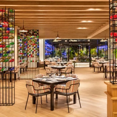salle de restaurants bar tables nappes blanches et chaises grises luminaires