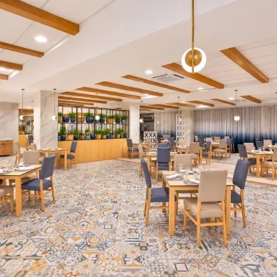 salle de restaurants bar tables nappes blanches et chaises grises luminaires