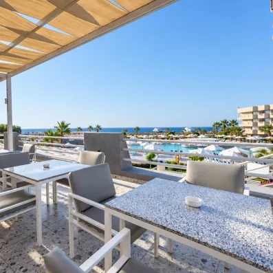 Terrasse panoramique du bar de l'hôtel Mondi Club Seven Seas Jolie Bay avec vue sur la mer.