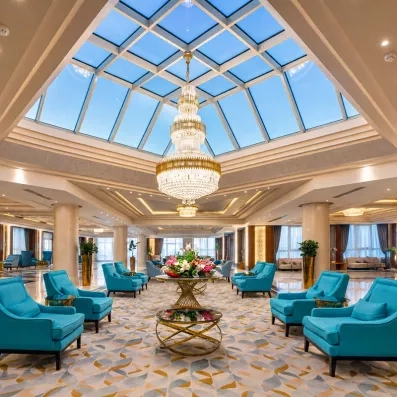 Grand hall de réception de l'hôtel Mondi Club Seven Seas Jolie Bay avec lustre en cristal et fauteuils bleus.