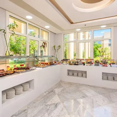 Espace buffet baigné de lumière avec vue sur le jardin au Mondi Club Seven Seas Jolie Bay.