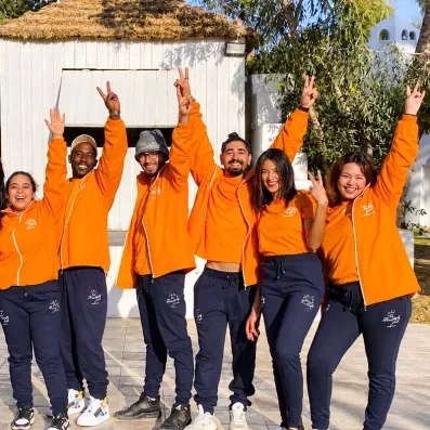 Équipe d'animation souriante en tenue orange au Mondi Club Shalimar à Hammamet.