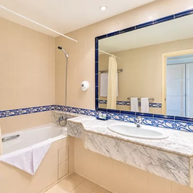Salle de bain en céramique bleue et blanche avec baignoire et grand miroir au Mondi Club Shalimar