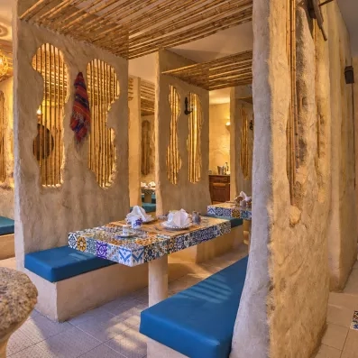 Niche de restauration traditionnelle avec tables en mosaïque et banquettes bleues au Mondi Club Shalimar Hammamet
