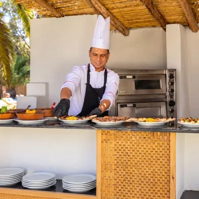 Chef préparant des pizzas au buffet extérieur de l'hôtel Mondi Club Shalimar à Hammamet, Tunisie.