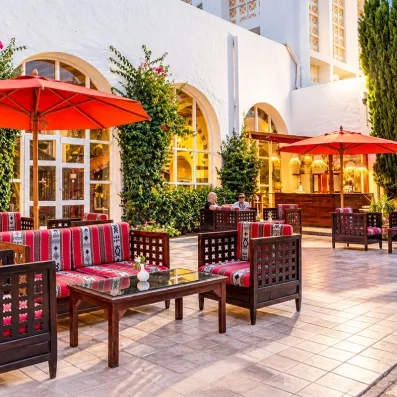 Terrasse extérieure avec salons orientaux et parasols rouges au Mondi Club Shalimar Hammamet