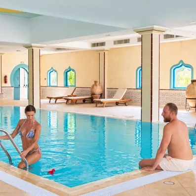 Femme sortant d'une piscine intérieure chauffée dans l'espace spa et détente du Mondi Club Shems Monastir.