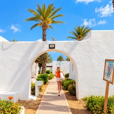 bungalowq blancs sur une allée avec palmiers au mondi club shems all inclusive à monastir