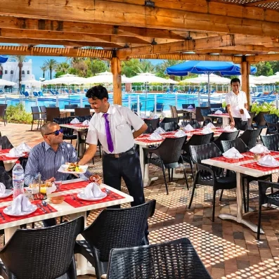 Service à table attentionné sur la terrasse ombragée du restaurant piscine au Mondi Club Shems Monastir.
