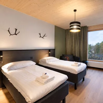 chambre double chaleureuse du mondi club sodankyla avec lits jumeaux et vue enneigée