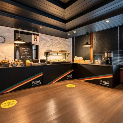 buffet du restaurant au Mondi Club Sodankylä avec aménagement en bois et comptoir noir marqué Peera Hotels.