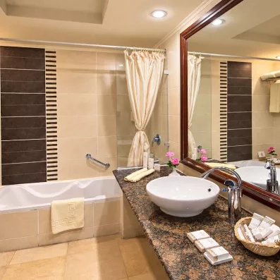 Salle de bain moderne avec baignoire et produits d'accueil, confort hôtelier au complexe Stella Garden Égypte.