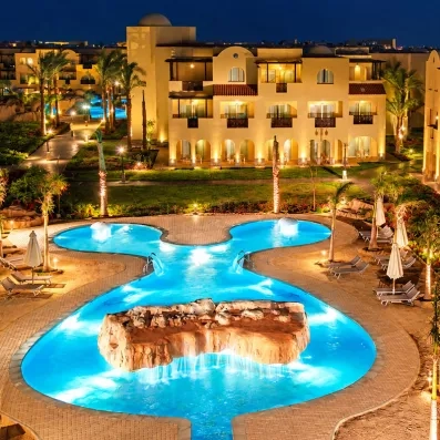 Éclairage nocturne spectaculaire de la piscine et des façades de l'hôtel Mondi Club Stella Garden.