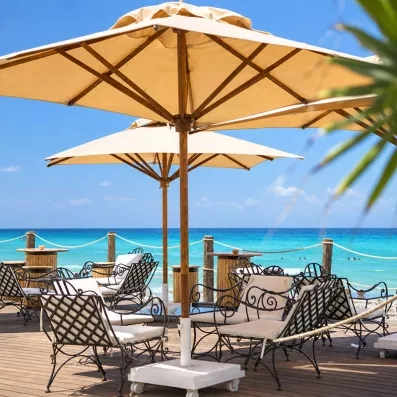 Terrasse extérieure aménagée avec parasols en toile et sièges confortables offrant une vue directe sur la mer à Mahdia.