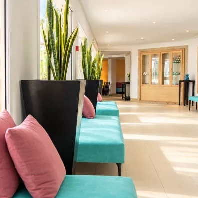 Espace lounge intérieur du centre de thalassothérapie du Mondi Club Mahdia avec banquettes turquoise et grands pots de plantes.