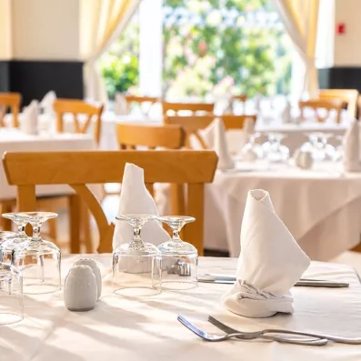 Gros plan sur une table élégamment dressée avec serviette pliée et verres au restaurant du Mondi Club Thalassa Mahdia.