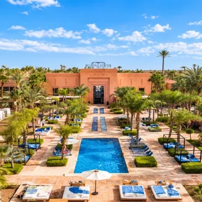 vue générale piscine avec transats parasols et palmiers