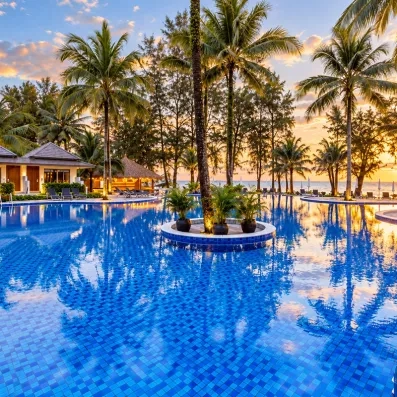 Une large piscine entourée de palmiers et de jardins tropicaux 