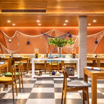 Une salle de restaurant décorée de filets de pêche, et d'un mobilier en bois chaleureux.