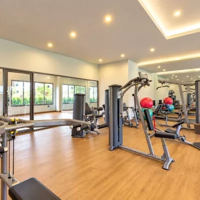 Une salle de sport lumineuse et bien équipée, offrant divers appareils de musculation.