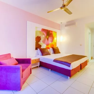 chambre avec un lit double et un canapé rose