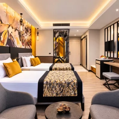 chambre avec deux lits simples et coin salon