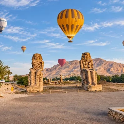 Montgolfières survolant les colosses de Memnon à la rive ouest de Louxor pendant une croisière sur le Nil.