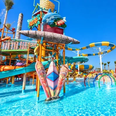 Aire de jeux aquatiques pour enfants avec dauphin décoratif et toboggans au Blend Club Aqua Resort Hurghada.