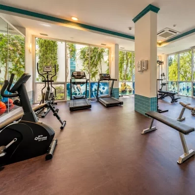 Une salle de sport lumineuse équipée de tapis de course et de vélos.