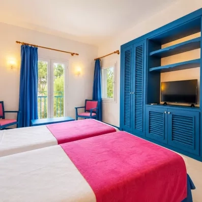 Un coin salon comprenant deux fauteuils, une grande armoire intégrée et une télévision.