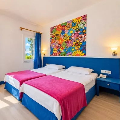 Une chambre lumineuse avec deux lits jumeaux et décorée dans les tons bleues et roses.