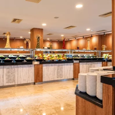 Un buffet de salades et d'entrées froides, dans une salle moderne et boisée.